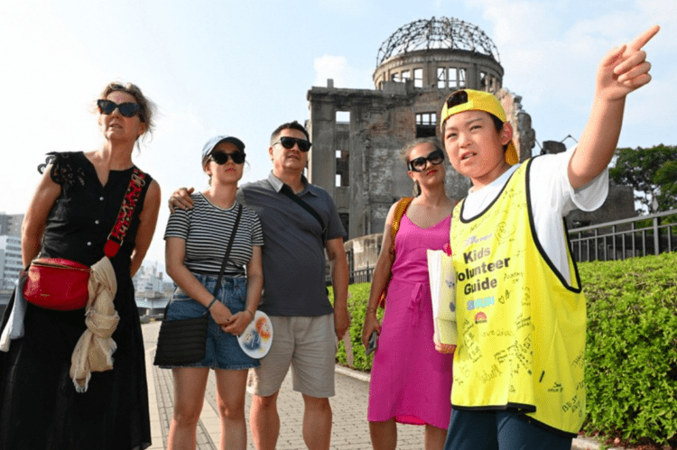 Guia mirim de 12 anos recebe visitantes estrangeiros a Hiroshima e relata em inglês o sofrimento da guerra